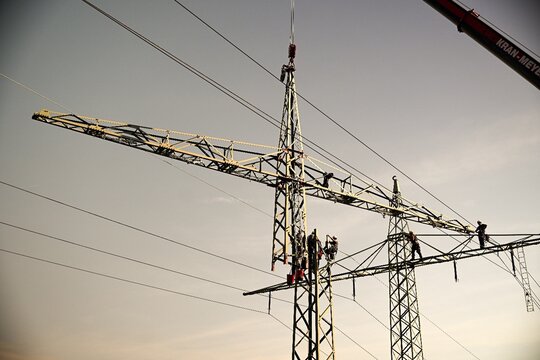 Arbeiten an einer 110 kV Trasse werden durchgeführt - Mast wird mit Kran aufgesetzt